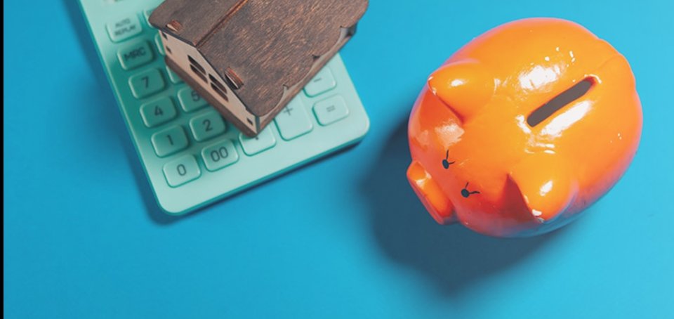 Piggy bank, calculator and house model